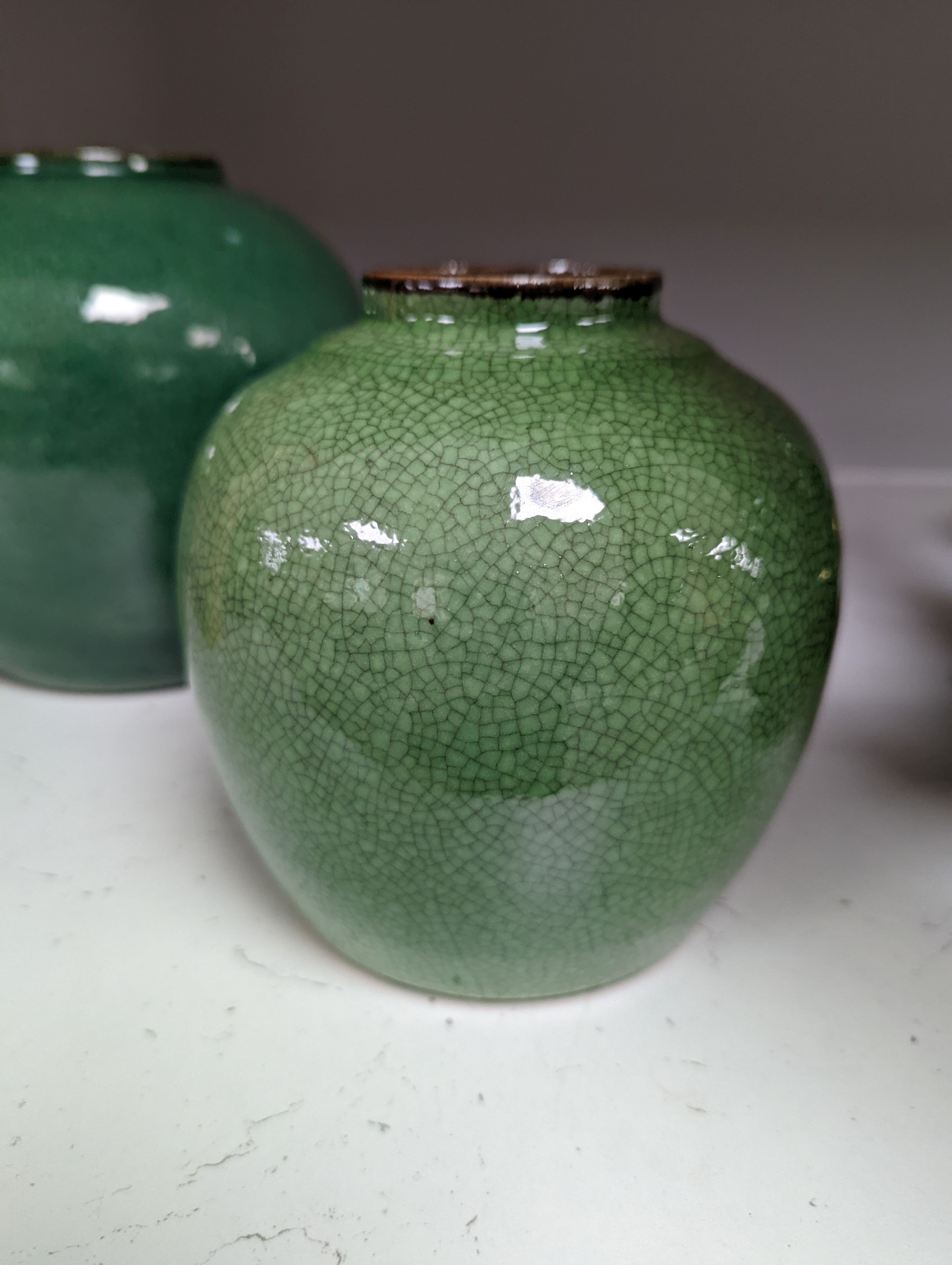 A 19th century Chinese green glazed model of a lion-dog, and two green crackle glaze jars, tallest 16cm